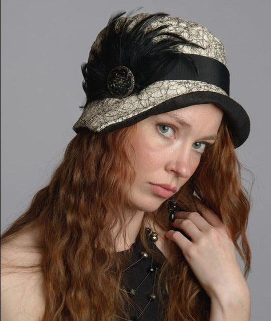 Woman wearing Abigail Hat in White Luna pattern with Black Band. Trimmed with Black Feather and Black Button. Handmade in Seattle WA| Pandemonium Millinery 