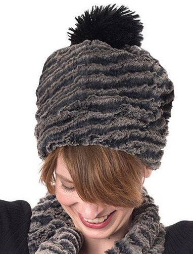 Woman modeling Beanie Hat reversible in Charcoal Desert Sand and Cuddly Black Faux Fur with Pom. Handmade by Pandemonium Millinery in Seattle, WA.