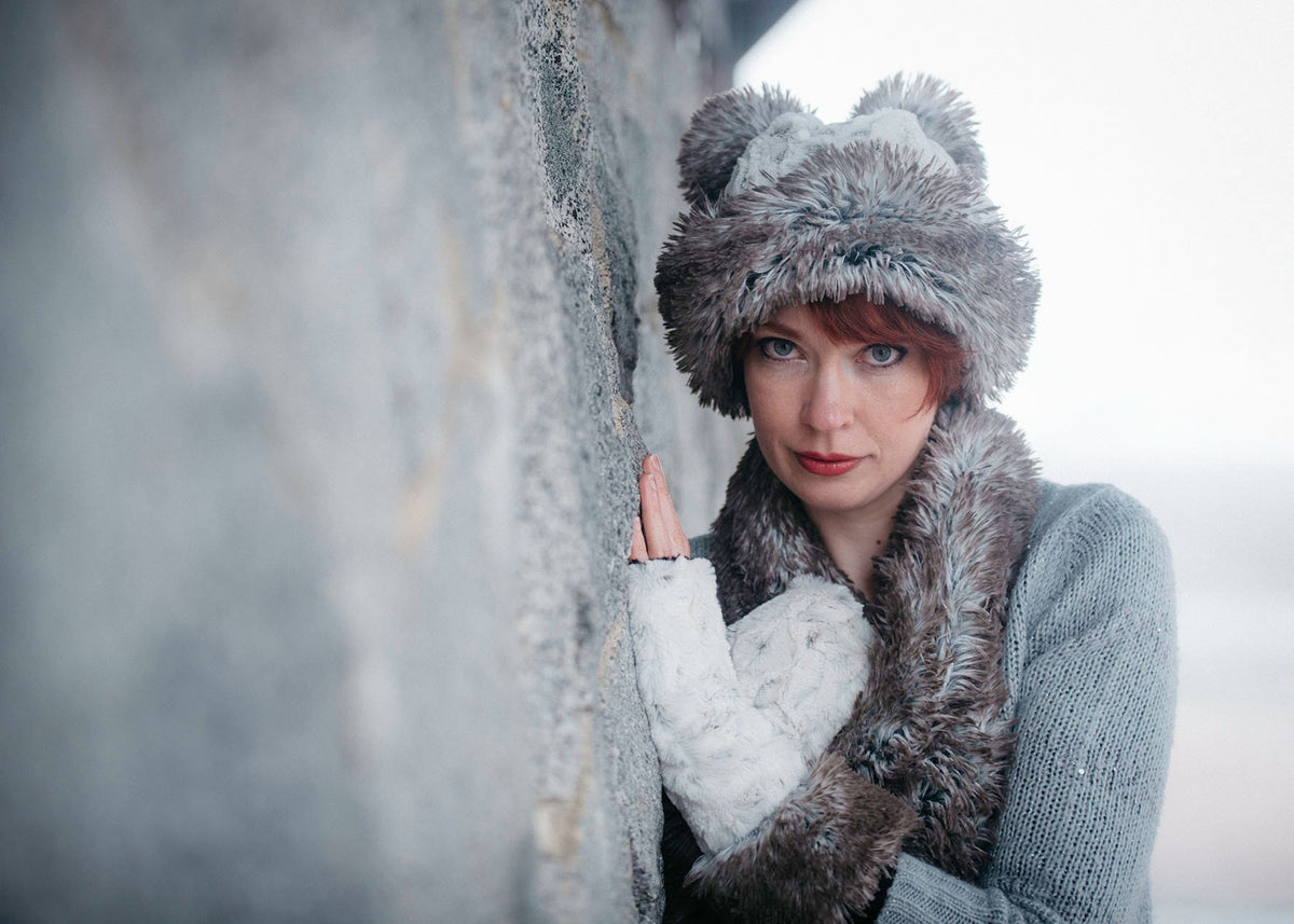 Woman modeling Beanie Hat, shown reversed in Luxury Faux Fur – Winter’s Frost and Arctic Frost Poms. Pandemonium Millinery in Seattle, WA.