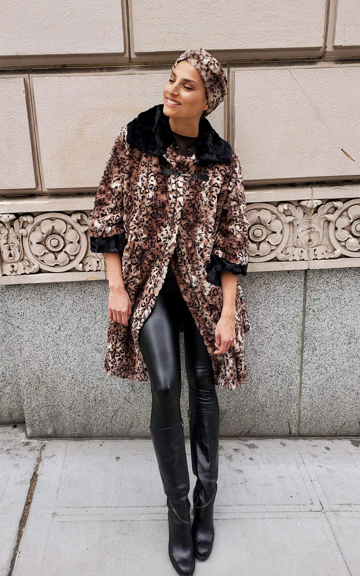 Model leaning against concrete building wearing Crawford Coat in Carpathian Lynx Animal Print Faux Fur | Handmade in Seattle WA | Pandemonium Millinery