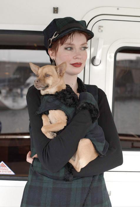 Girl wearing matching outfit holding chihuahua on boat wearing Designer Handmade reversible Dog Coat | wool Plaid in Nightshade upholstery fabric reversing to Black Faux Fur | Handmade by Pandemonium Millinery Seattle, WA USA
