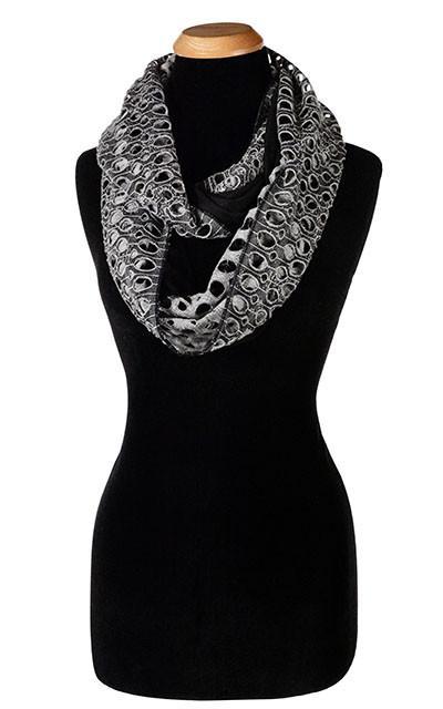 Ladies Two-Tone infinity, Eternity Loop Scarf on Mannequin | Lunar Landing, a black and neutral knit with curled edges surrounding holes, paired with a light-weight Black Jersey Knit | Handmade in Seattle WA | Pandemonium Millinery