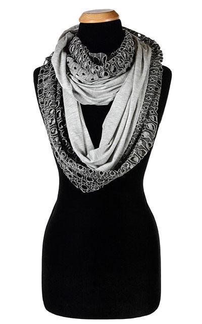 Ladies Two-Tone infinity, Eternity Loop Scarf on Mannequin | Lunar Landing, a black and neutral knit with curled edges surrounding holes, paired with a light-weight Silver Gray Jersey Knit | Handmade in Seattle WA | Pandemonium Millinery
