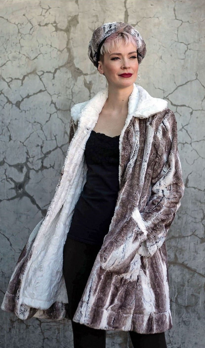 Model against a Gray cement wall wearing Garland Swing Coat  and Matching Beret| Birch Brown and Ivory Faux Fur and Cuddly Ivory | Handmade in Seattle WA | Pandemonium Millinery