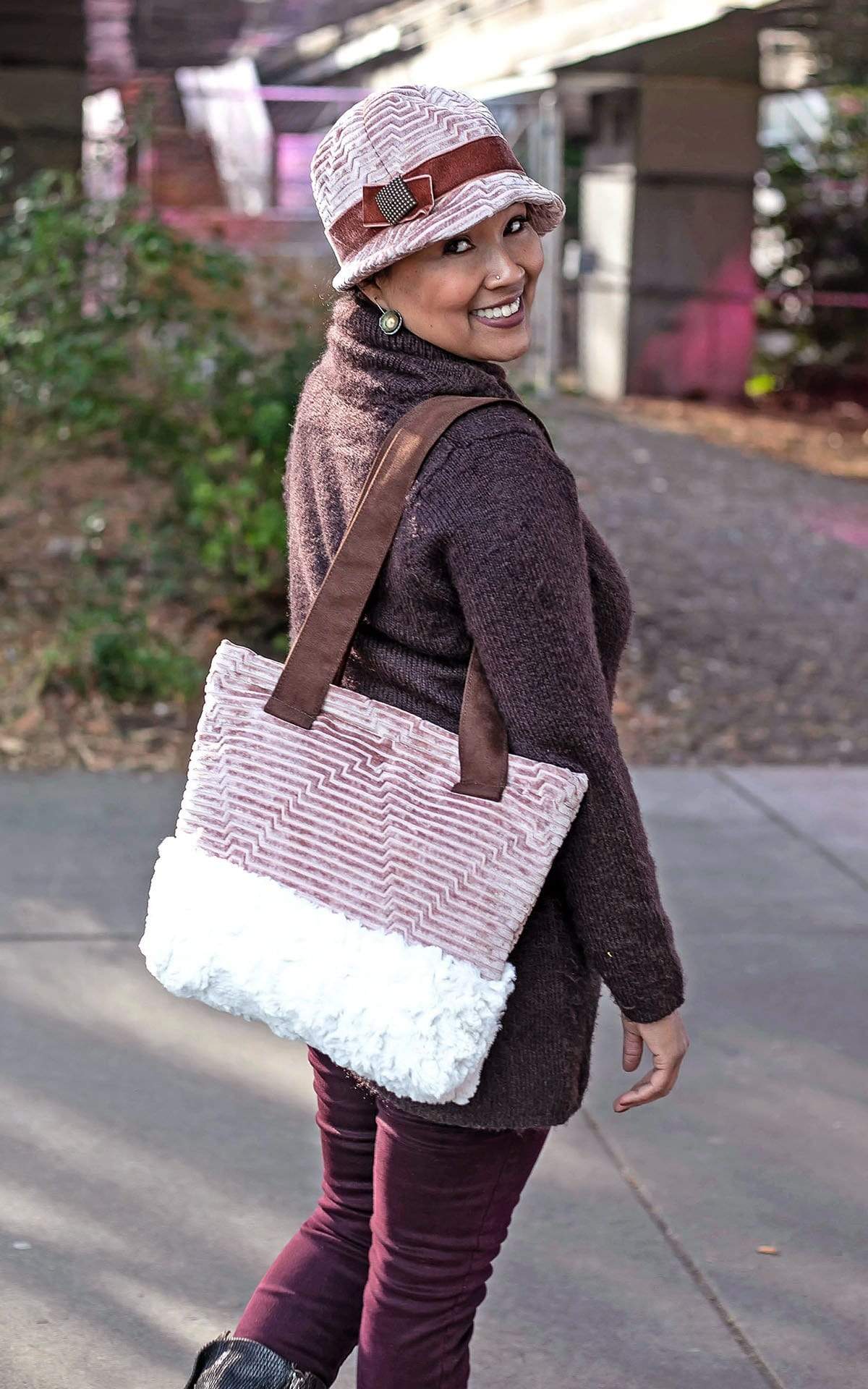  Full Body Shot of Model wearing a Grace Style 1920s Cloche and Matching Tote Bag |  Hat Fabric is  Chenille in Cherry Blossom with Rouge pink Velvet Band and Bow with a Copper Square Button Trim | Bag Fabric Features Faux Leather Handles and Chenille and Faux Faux Body By Pandemonium Millinery | Seattle WA USA