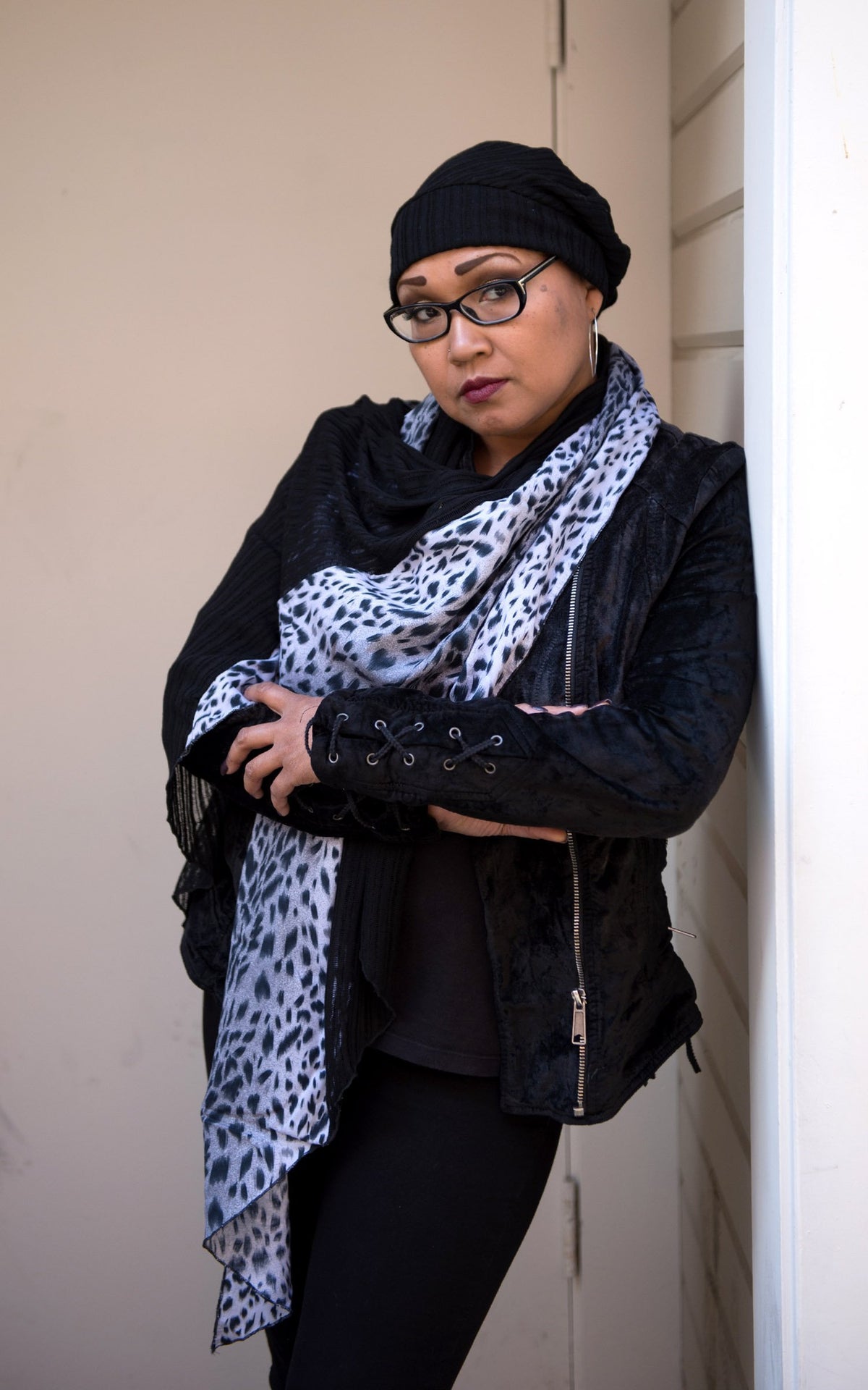 Model leaning against a Doorway wearing Rowdie slouchy style hat and matching  Ladies Two-Tone Handkerchief Scarf, Large Wrap | Shown in White Burmese animal print on Cotton with Abyss (Black) Jersy Knit | Handmade in Seattle WA | Pandemonium Millinery