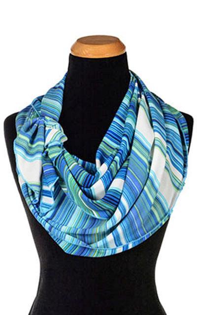 Women’s Large Handkerchief Scarf, Wrap on Mannequin shown double wrapped and tied on side| Shown in Sea Breeze a striped pattern on blues, turquoise, greens, and ivory | Handmade in Seattle WA | Pandemonium Millinery