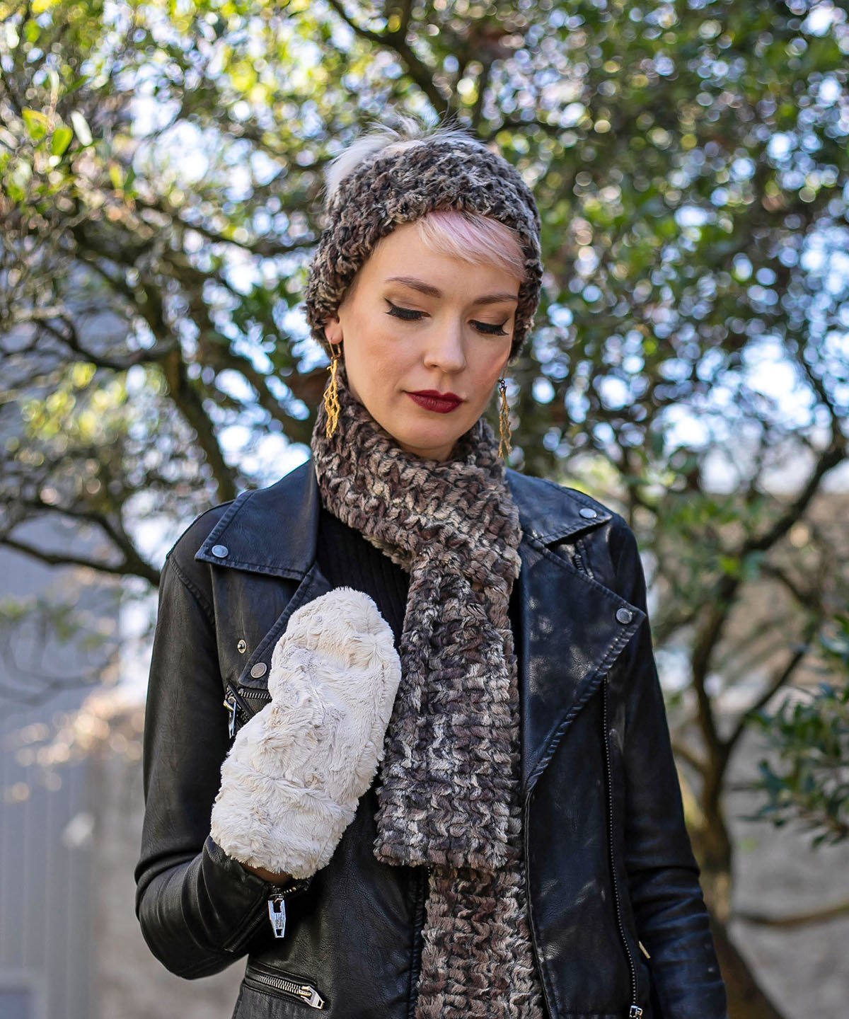 Model in front of  tree in wearing a black leather jacket and faux fur Headband, scarf and mittens | Calico, brown, chocolate and Ivory Faux Fur | Handmade by Pandemonium Millinery Seattle, WA USA