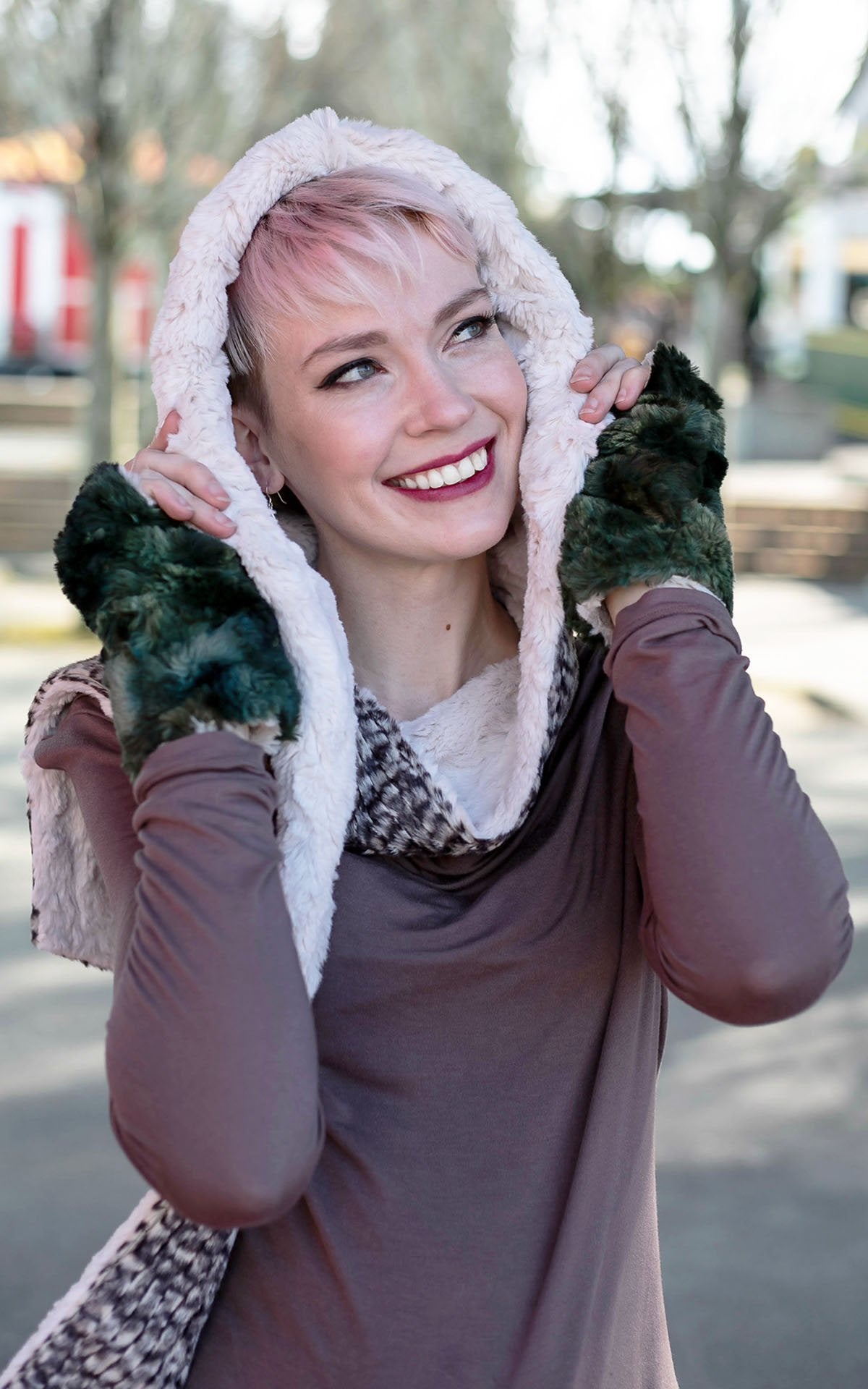 Close-up of women smiling wearing fingerless gloves in green and a Two-Tone Hooded Scarf | Cobblestone faux fur, a mix of browns, tans, and creams with cuddly fur in Sand Faux Fur | Handmade in Seattle WA | Pandemonium Millinery