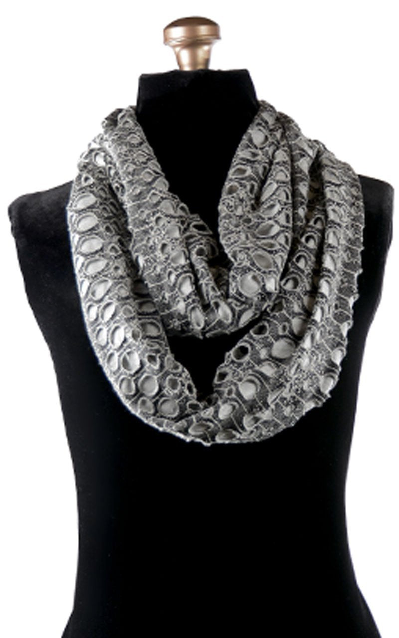 Model wearing scrunched Fingerless Gloves and Edith slouchy hat with matching Infinity loop Scarf | Lunar Landing, a black and neutral knit with curled edges surrounding holes, paired with a light-weight tan Jersey Knit | Handmade in Seattle WA | Pandemonium Millinery