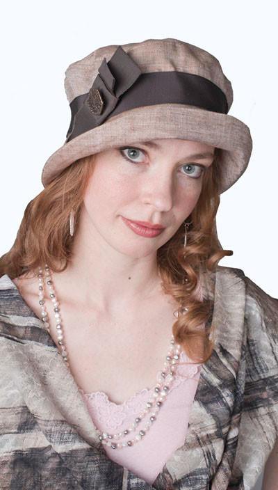 A Model wearing Molly Bucket Hat in Coral Linen featuring a Chocolate Band and Bow with Hexagon Copper Button| By Pandemonium Millinery in Seattle WA