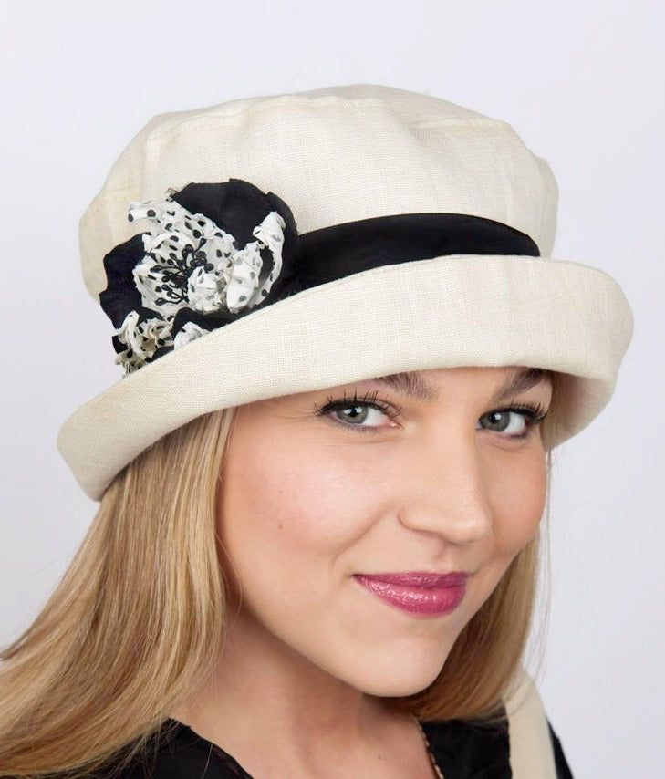 Woman wearing a Molly Bucket Style Hat Seashell Linen with Black Band featuring a White and Black Polka Dot Flower Trim | Handmade By Pandemonium Millinery | Seattle WA USA