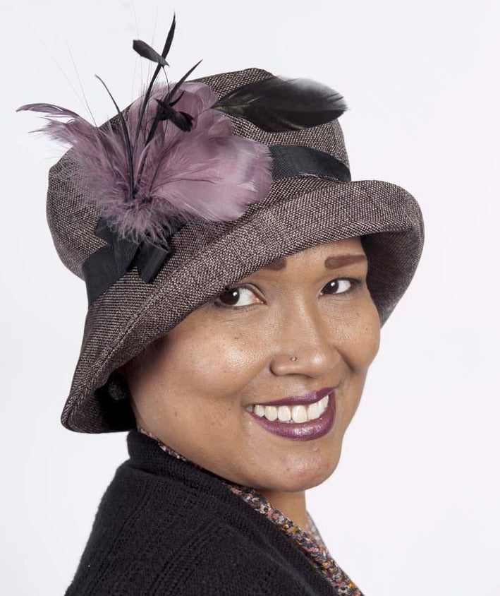 Model wearing Molly Bucket Origin in Java | Black Grosgrain Band with Mauve an Black Feather Brooch | Handmade By Pandemonium Millinery in Seattle WA