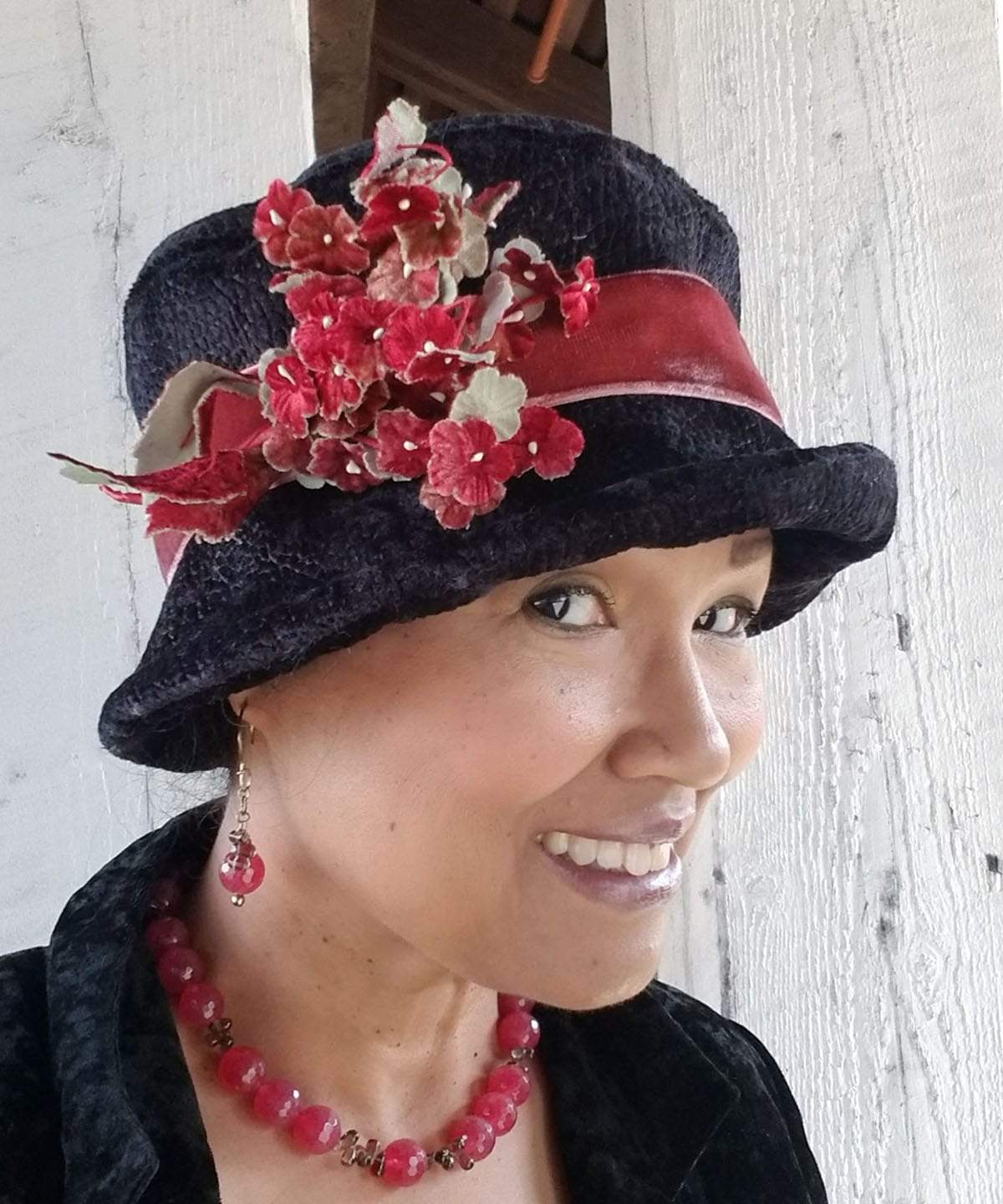 Women wearing Molly Bucket Style Hat Pebbles in Black Upholstery Fabric with Rouge Velvet Band Featuring Velvet Red Flowers Brooch | Handmade by Pandemonium Millinery | Seattle WA USA