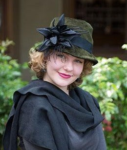 Modeling wearing Olivia Hat Cohen in Olive Upholstery Fabric | Black Band with a Custom Flower Brooch| Handmade By Pandemonium Millinery | Seattle WA