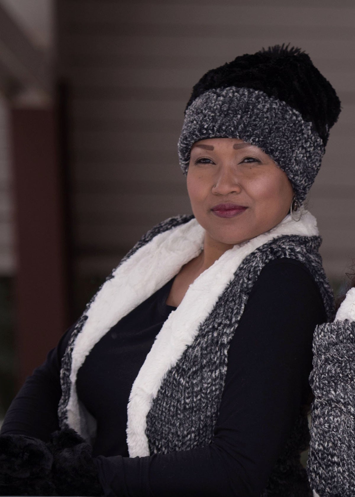 Model sitting down wearing Shawl Collar Vest | Cozy Cable in Ash Black and White with Cuddly Ivory Faux Fur | Handmade In Seattle WA | Pandemonium Millinery