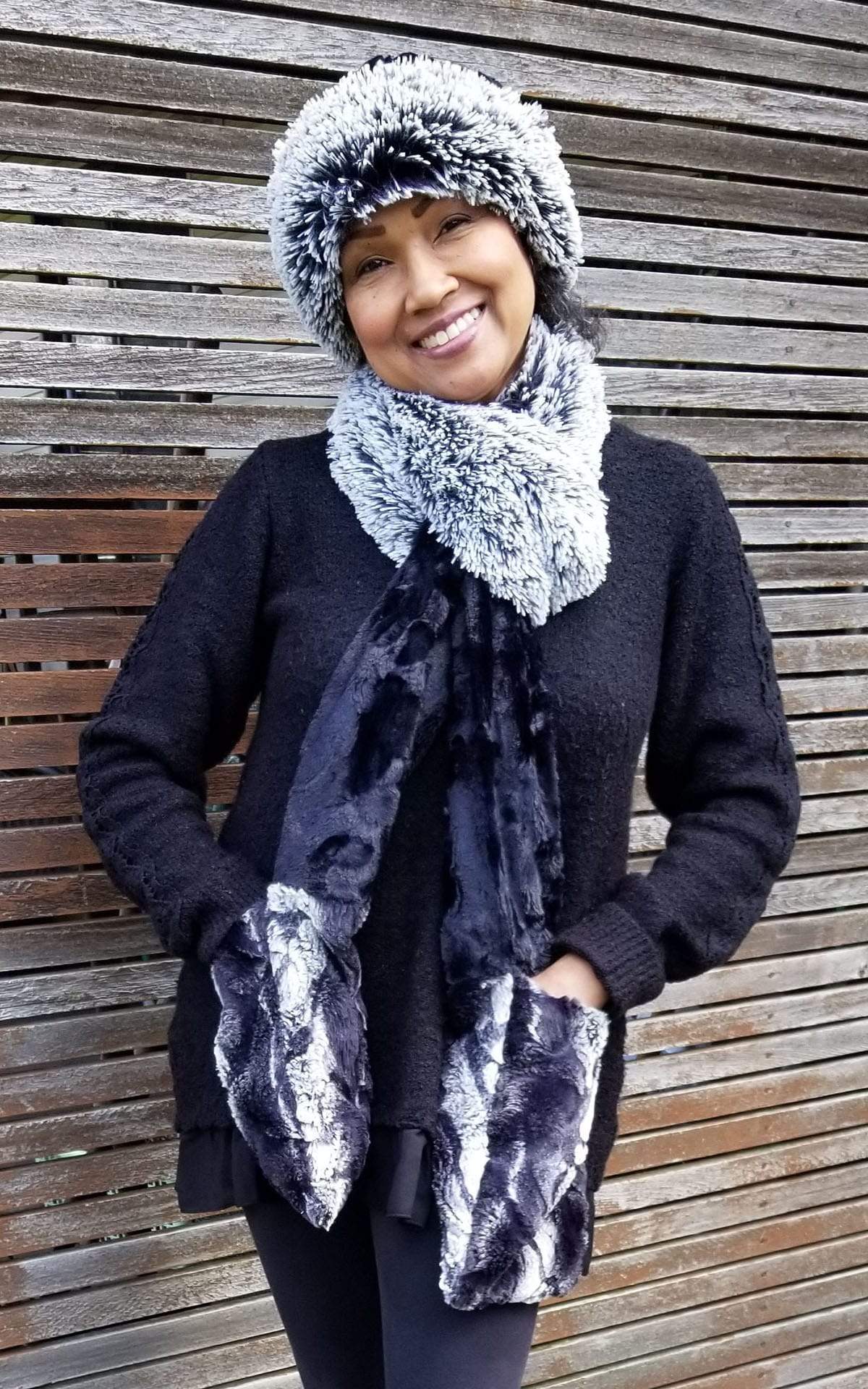 Women leaning against wood wall wearing Cuffed Pillbox and Matching  Color Block  Tri-Color Pocket Scarf | Silver Tipped Fox in Black, Honey Badger and Cuddly Black a  combo of blacks and cream, long and short hair Faux Fur | Handmade in Seattle WA Pandemonium Millinery