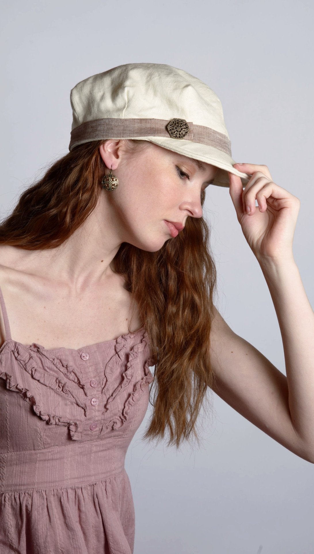 Woman wearing Valerie Newspaper Boy Style Cap in Linen in Seashell | Coral Linen Band with Metal Button | Handmade by Pandemonium Millinery | Seattle WA USA