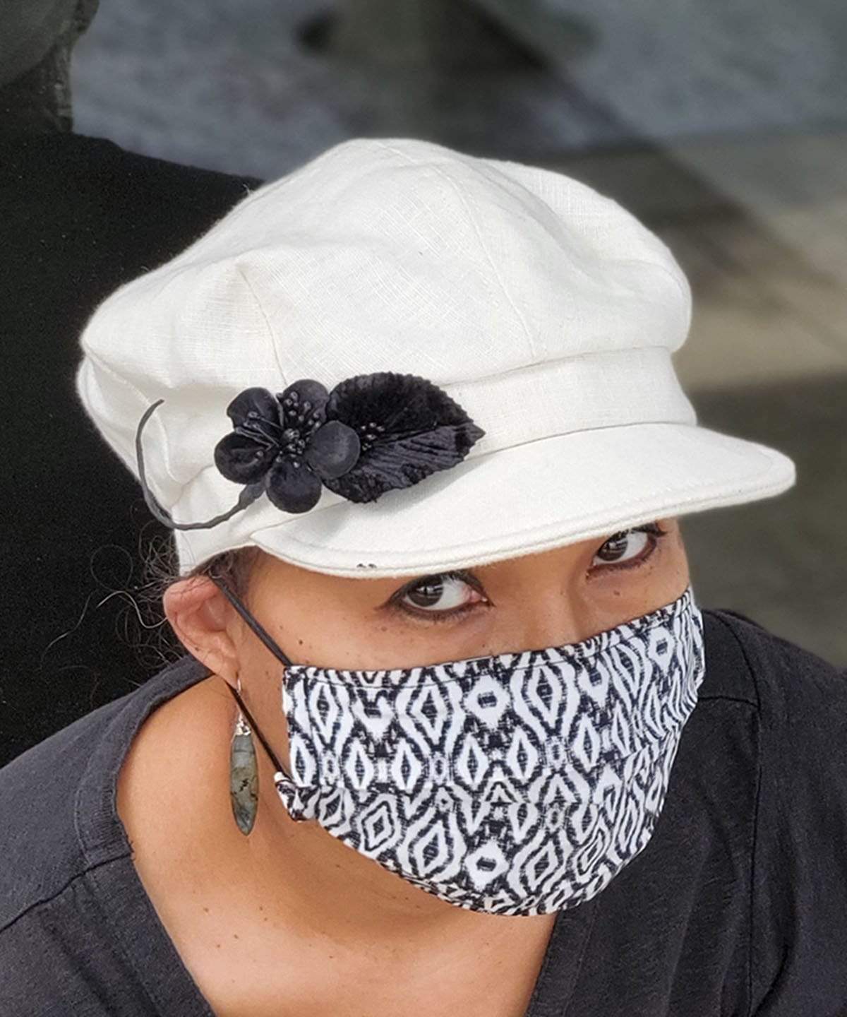 Woman wearing a Valerie Style Cap in Linen in Seashell | Black Velvet Flower Brooch | Handmade by Pandemonium Millinery | Seattle WA USA