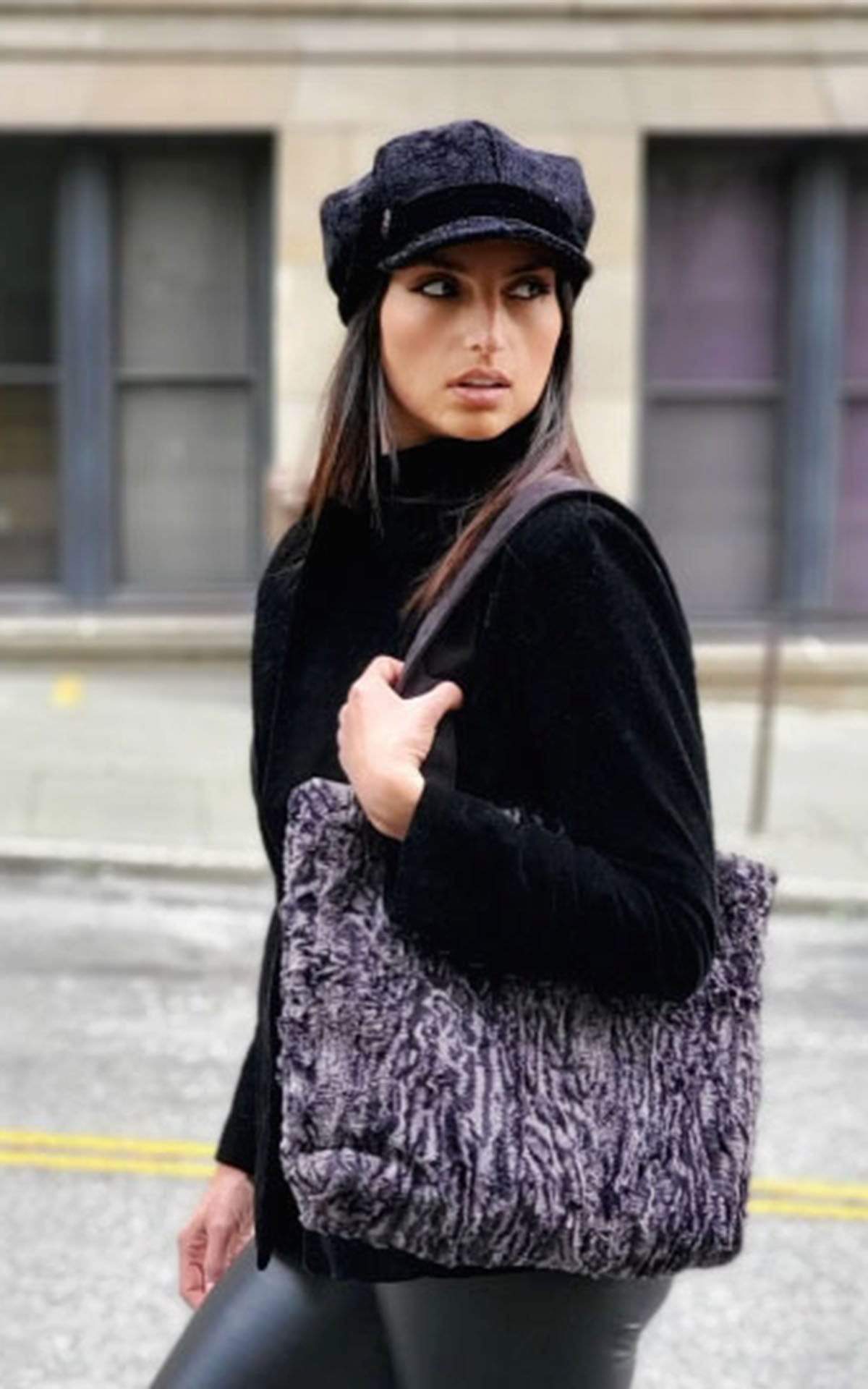 A model wearing a Valerie Cap Style hat in Pebbles in Black with Black Velvet Band with Siberian Lynx Tote bag.  Handmade in Seattle, WA USA by Pandemonium Millinery.