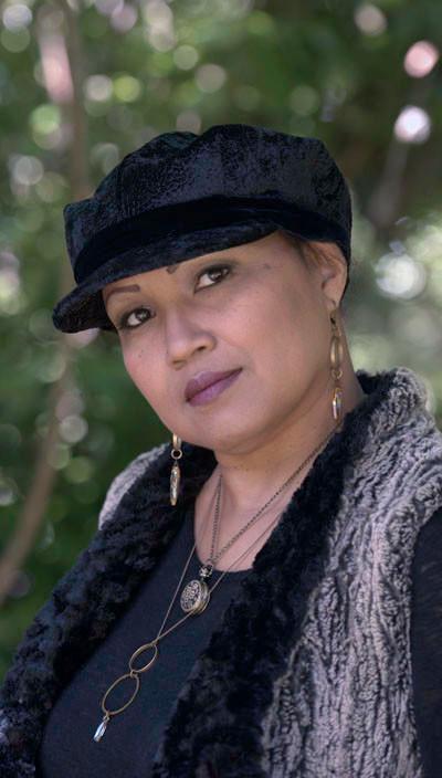 Valerie Cap Style hat in Pebbles in Black with Black Velvet band and button on a model, providing a side view of the hat.  handmade in Seattle, WA USA by Pandemonium Millinery.