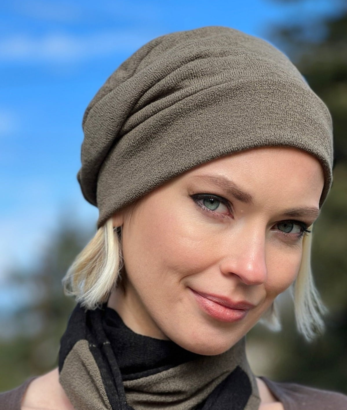 Close up view of woman wearing the Rowdie Hat in Mezcal. This Rowdie is made in soft crepe fabric. Handmade in Seattle, WA.