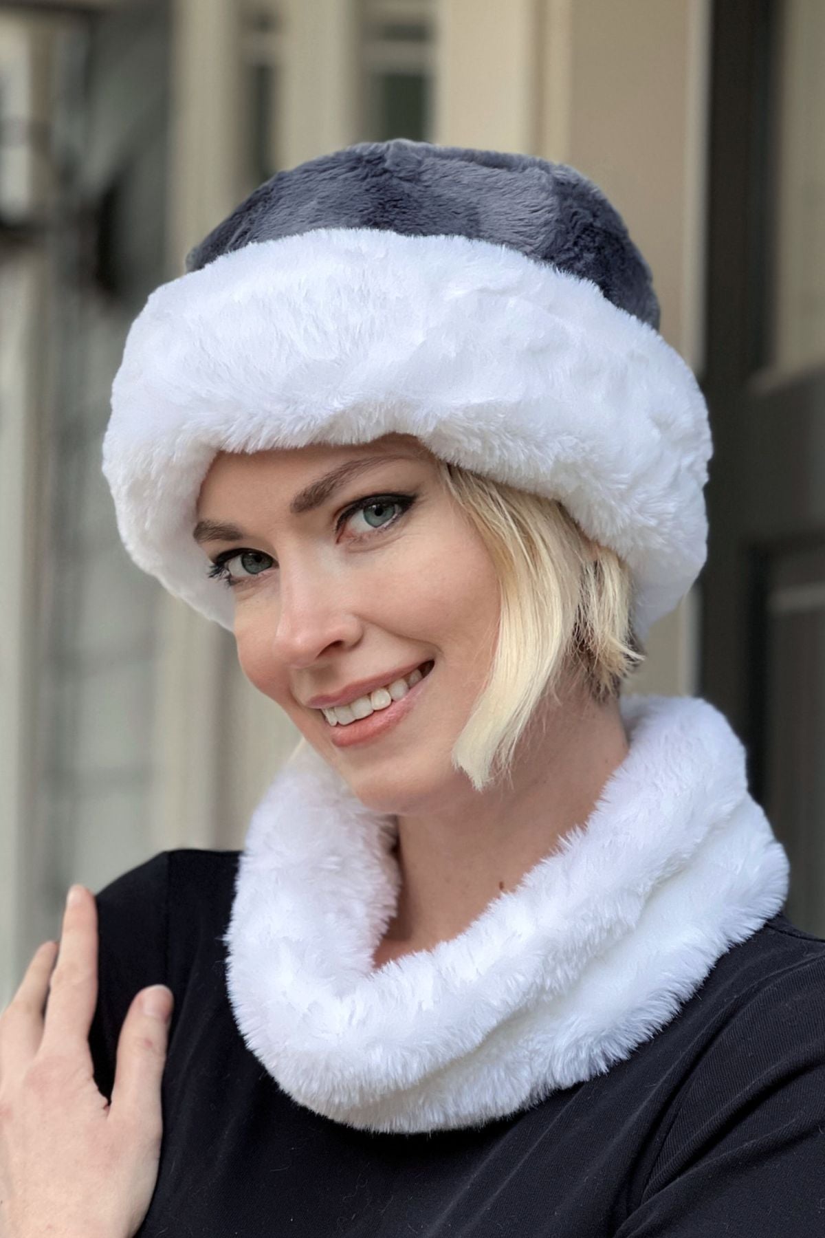 Woman wearing a Royal Opulence Cuffed Pillbox in Heavenly reversed to show the Cuddly Slate side, and an Heavenly Ear/Neck Cozy (Narrow). Handmade by Pandemonium Seattle.