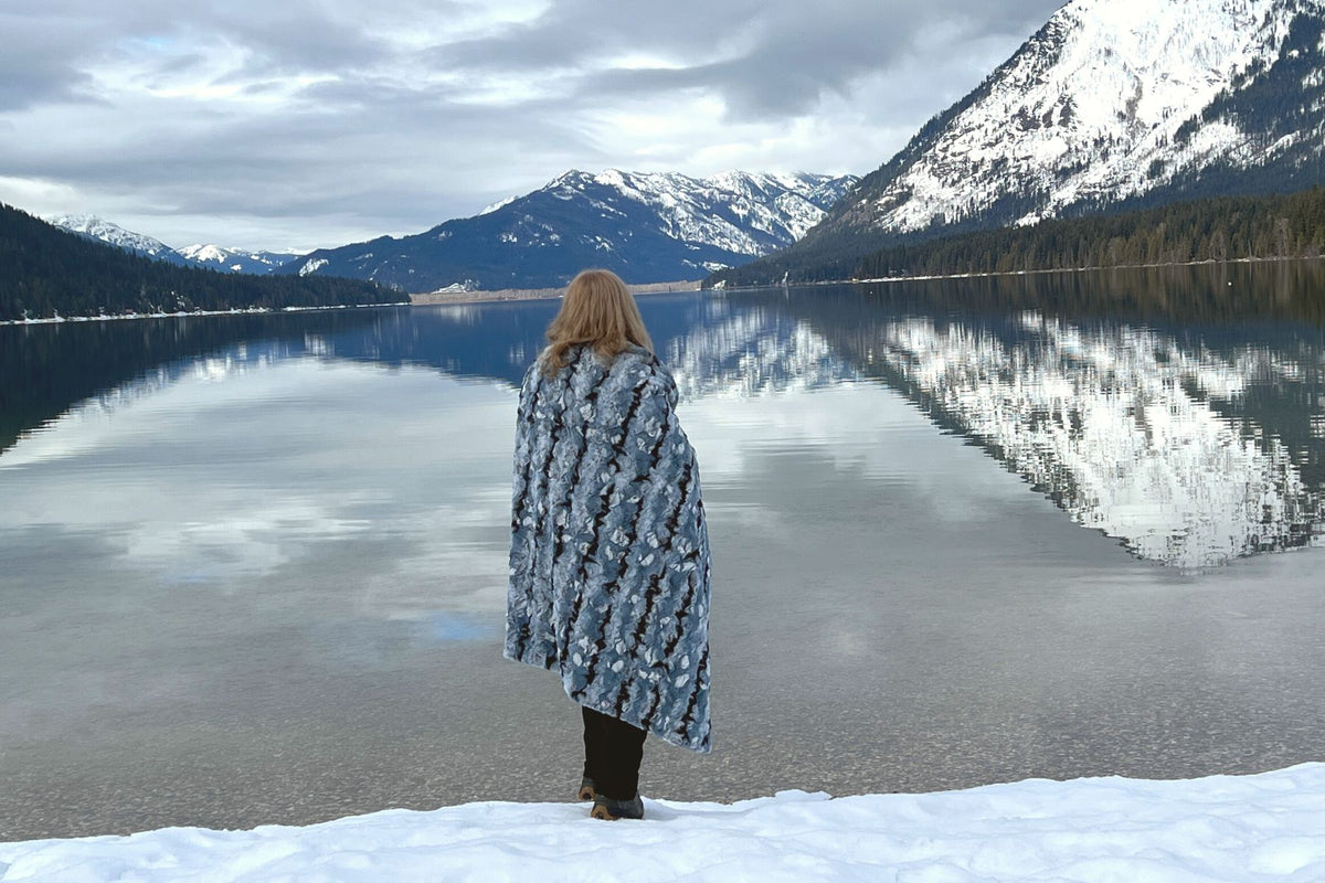 Throw Blanket on woman standing in front of mountain lake | Rainier Sky Luxury Faux Fur | Handmade in WA, USA by Pandemonium Seattle