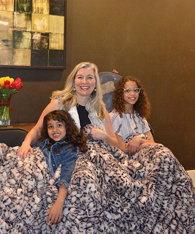 Mother and her daughter bundled up in Throw in Snow Leopard From Royal Opulence Collection Handmade in Seattle