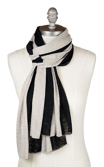 model in front of red wood and brick wall wearing a matching rowdie hat and  Upcycled Motley Scarf in the small pattern. Two colors, Sandstone and Scorpion in an alternating pattern. Handmade in Seattle, WA by Pandemonium Seattle.