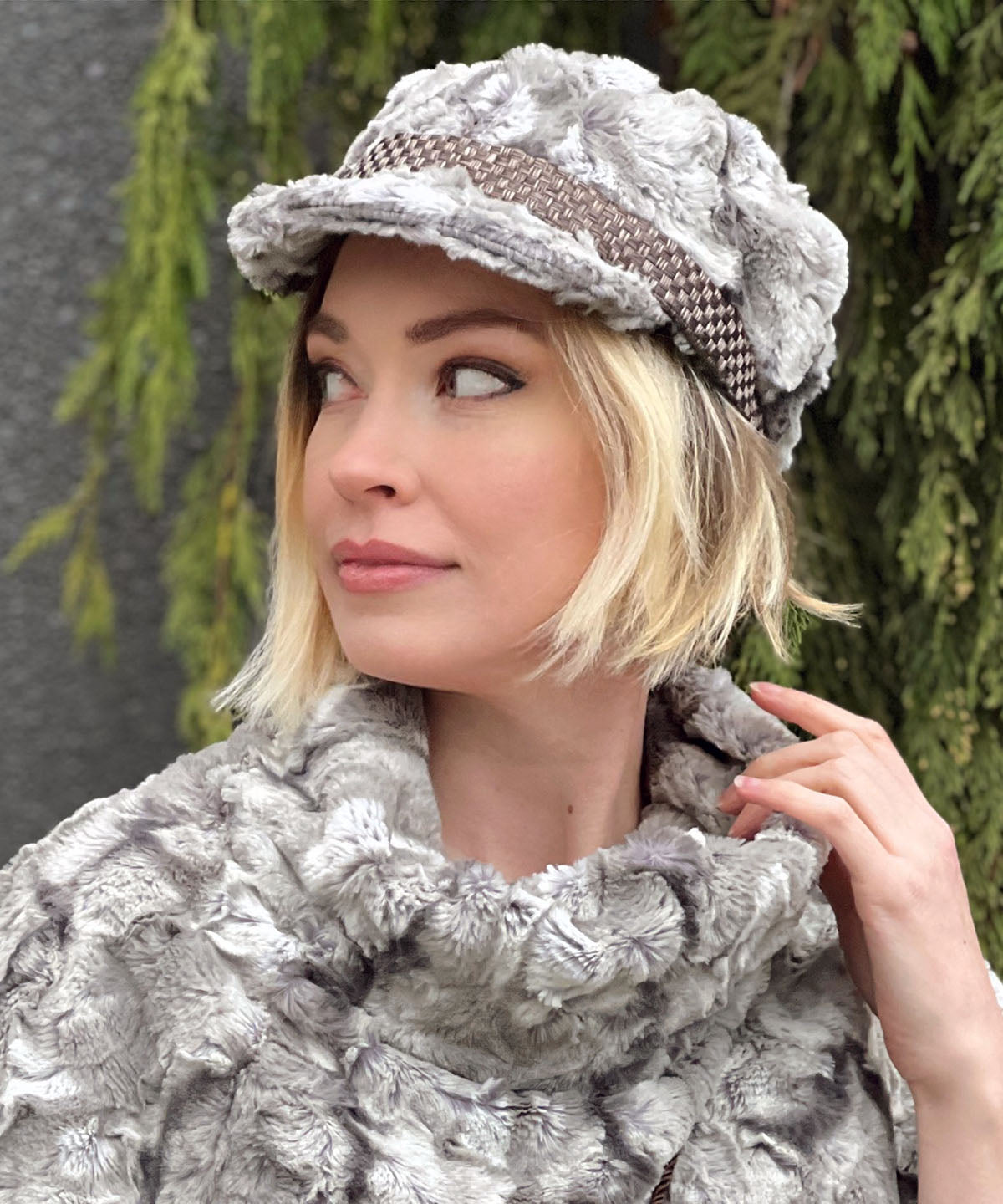 Left side view of model wearing Valerie Cap Style hat in White Water Faux Fur and White Water Sweater Top.   Handmade in Seattle, WA by Pandemonium Millinery in USA.