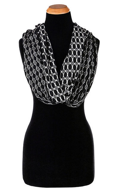 Women’s wide infinity Scarf, Wrap on Mannequin | Lunar and Solar Eclipse, black knit with white lattice patterning exposing sections of gray and white| Handmade in Seattle WA | Pandemonium Millinery